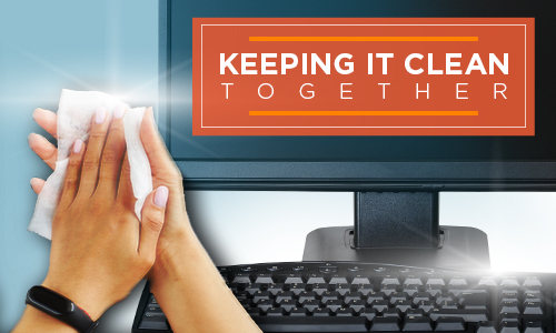 hands with cleaning rag and desktop computer with keyboard